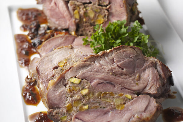 Shoulder of Lamb with apricot and pistachio stuffing served on a white dish